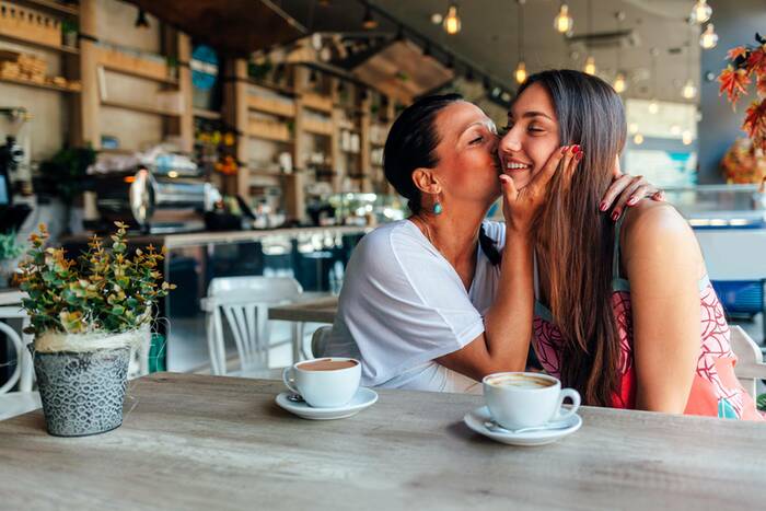 mum kissing daughter on cheek